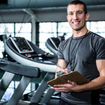 Fitness trainer in a gym holding a clipboard