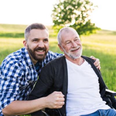 Young man carer with an elderly gentleman in a wheelchair