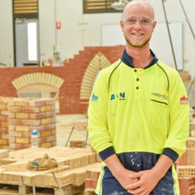 Bricklayer standing in front of a wall