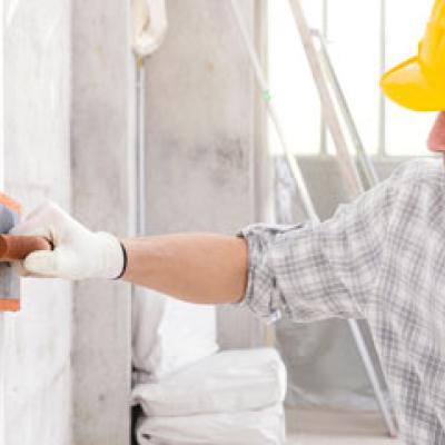 Plasterer applying plaster to a wall