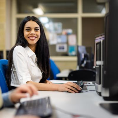 South Metropolitan TAFE business student Addison Roode pictured sitting at a computer and smiling.