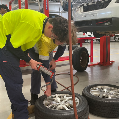 Two male students looking at a tyre 