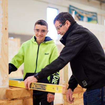 A student and lecturer working on laying bricks