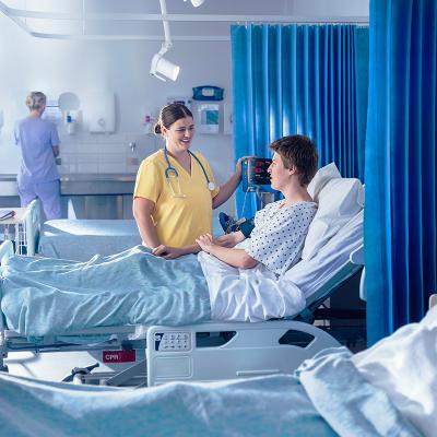 nurse helping patient in hospital bed