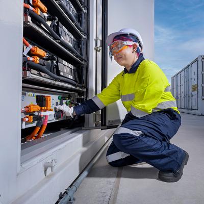 fitter squatting in front of big battery