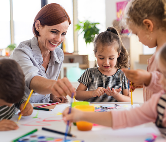 Person helps children with activities.