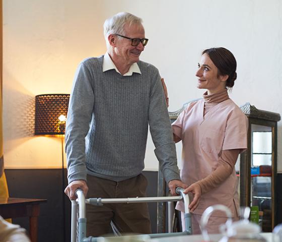 Support worker assists patient sit up.
