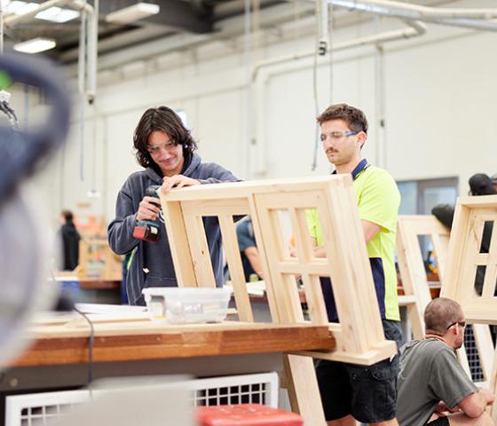 Image of 2 students building a window frame out of wood