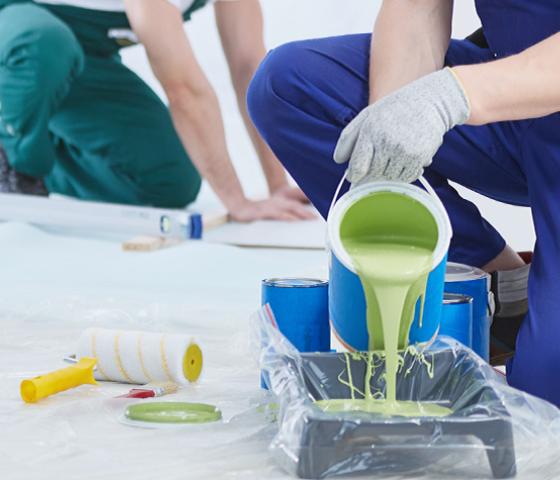 painter pouring paint into container